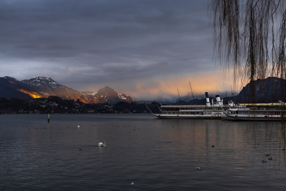 a large boat floating on top of a lake under a cloudy sky