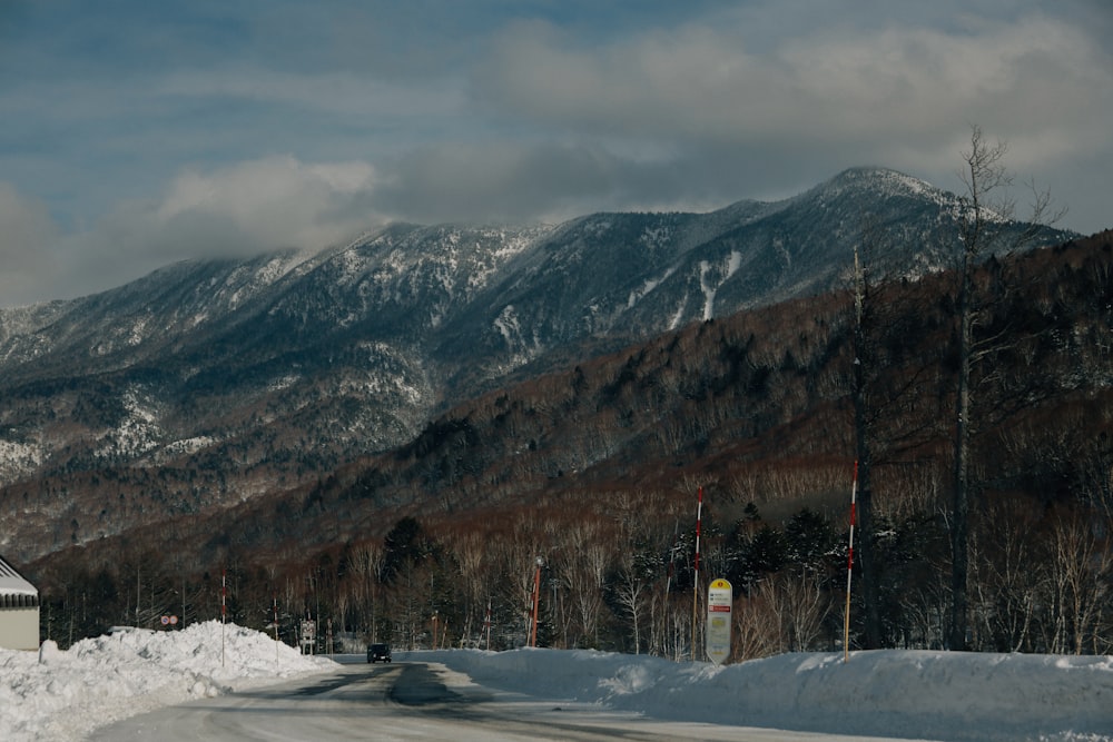 a snow covered road with a mountain in the background