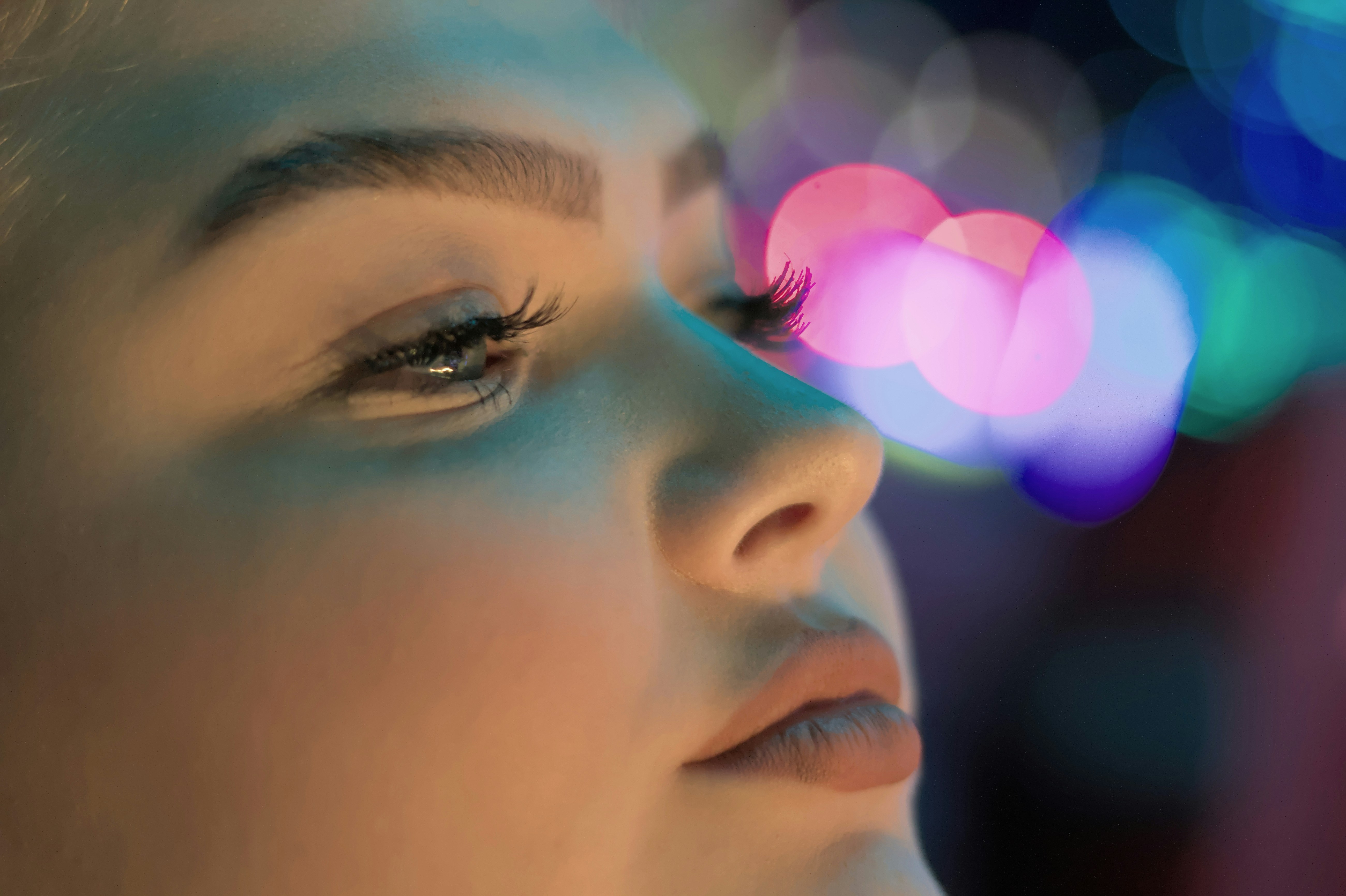 a close up of a woman's face with bright lights in the background