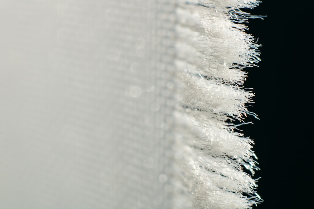 a close up of a white curtain on a black background