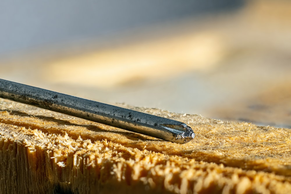 a close up of a metal object on a piece of wood