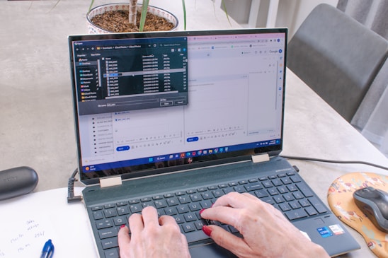 A person filling out a digital form on a laptop in a bright workspace.
