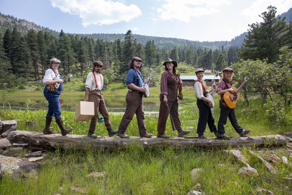 a group of people walking across a wooden bridge