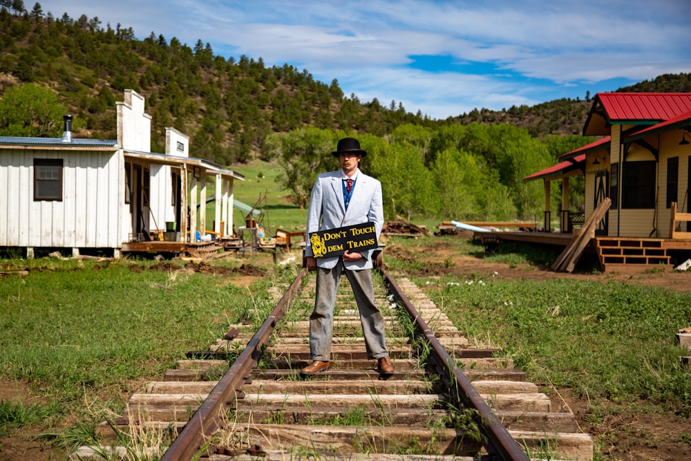 a man standing on a train track holding a sign