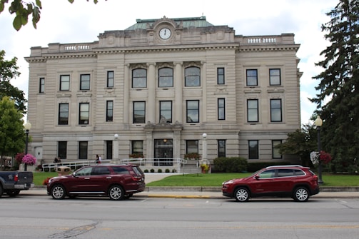 two cars parked in front of a large building