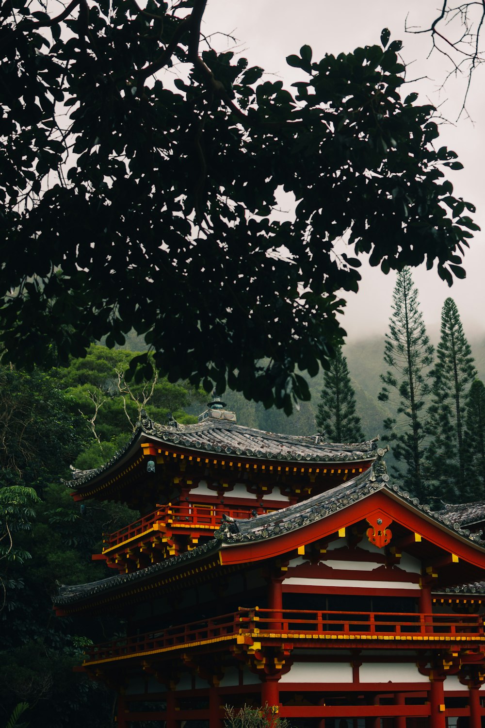 a tall red building sitting next to a forest