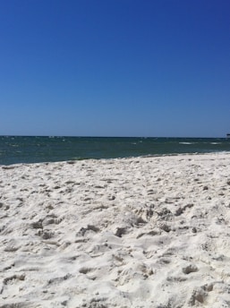 A serene coastal view of Costa Blanca with a clear blue sky and sandy beach.