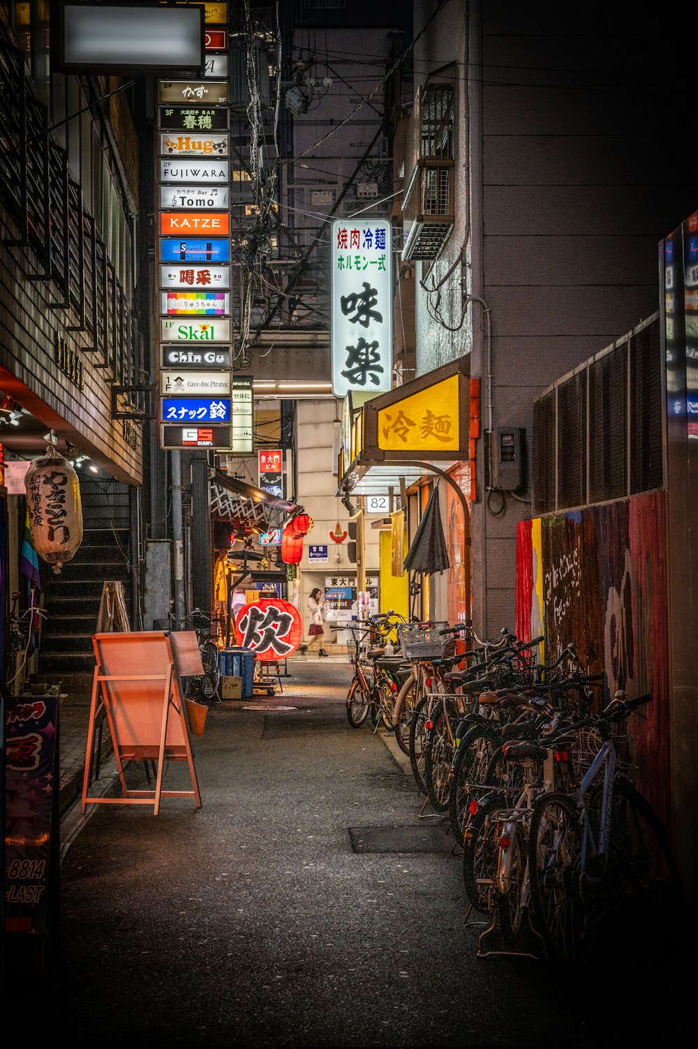 a narrow city street with lots of bikes parked on the side of it