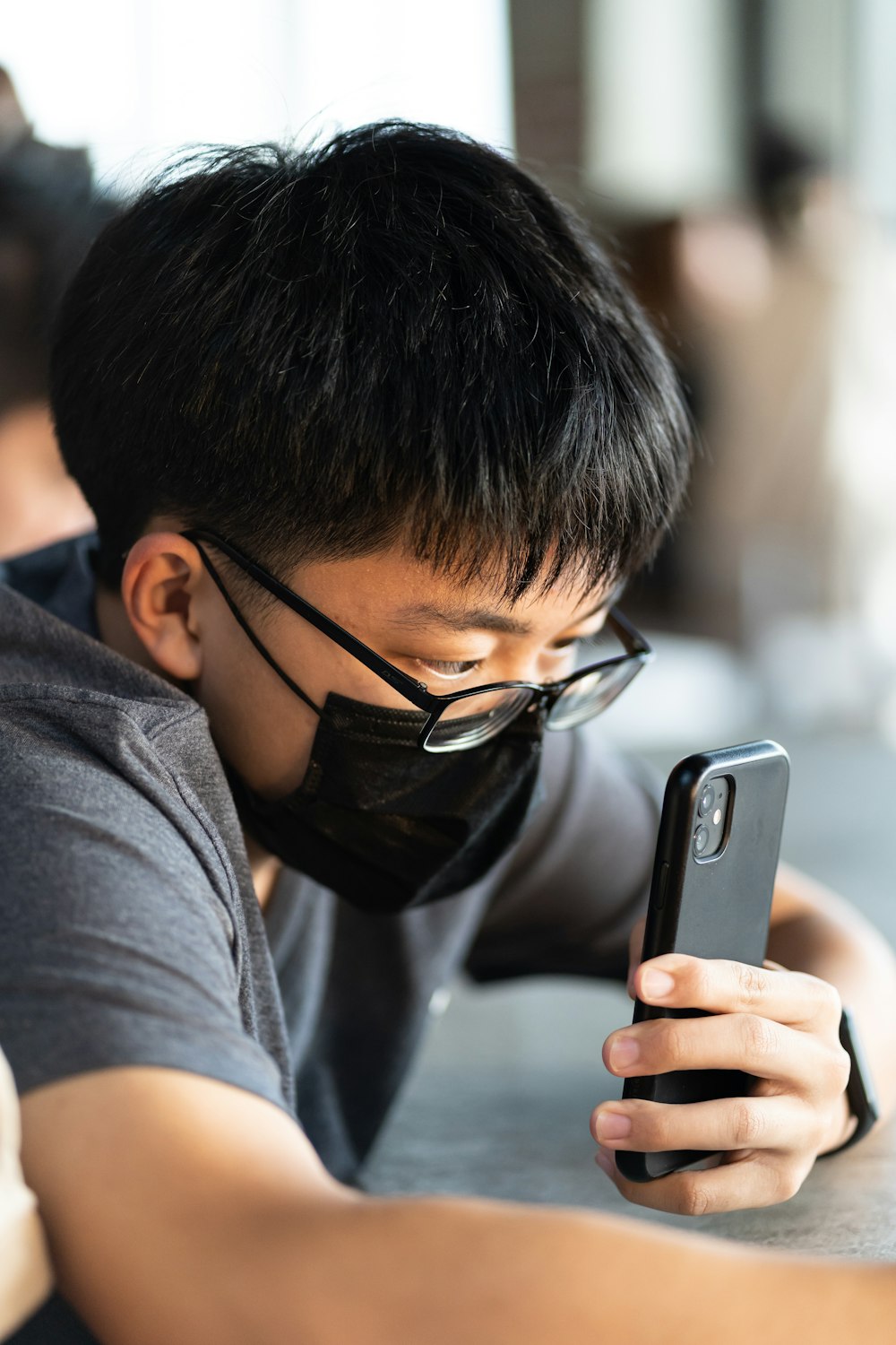 a man wearing a face mask looking at a cell phone