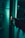 A person is holding a lighter with a small flame in front of an open refrigerator. The lighting is dim and has a greenish tint, giving a moody atmosphere. Shadows are cast on the hands, and various objects are faintly visible inside the refrigerator.
