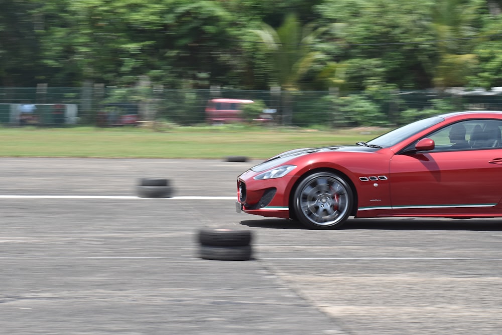 a red sports car driving down a race track