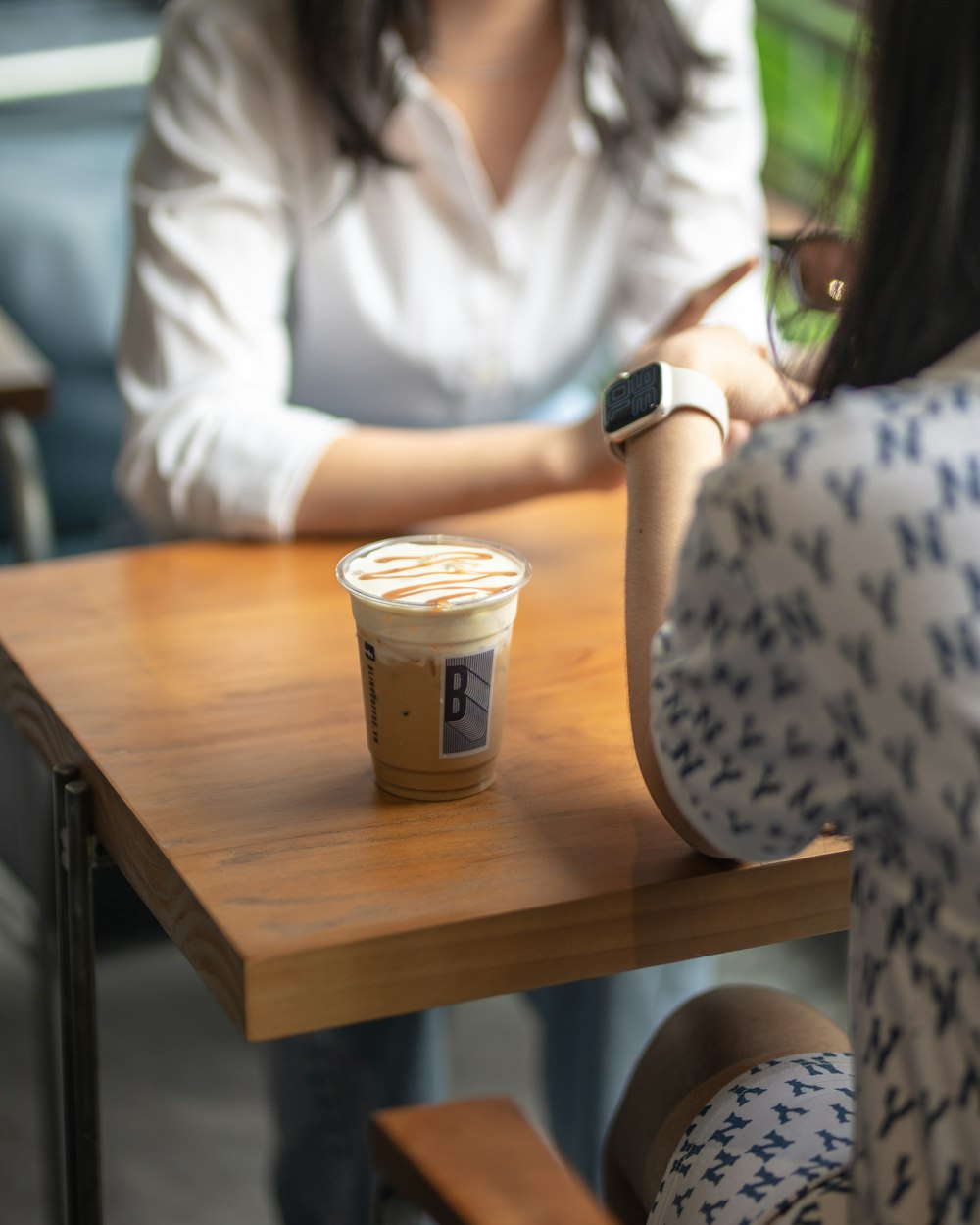 a woman sitting at a table with a cup of coffee