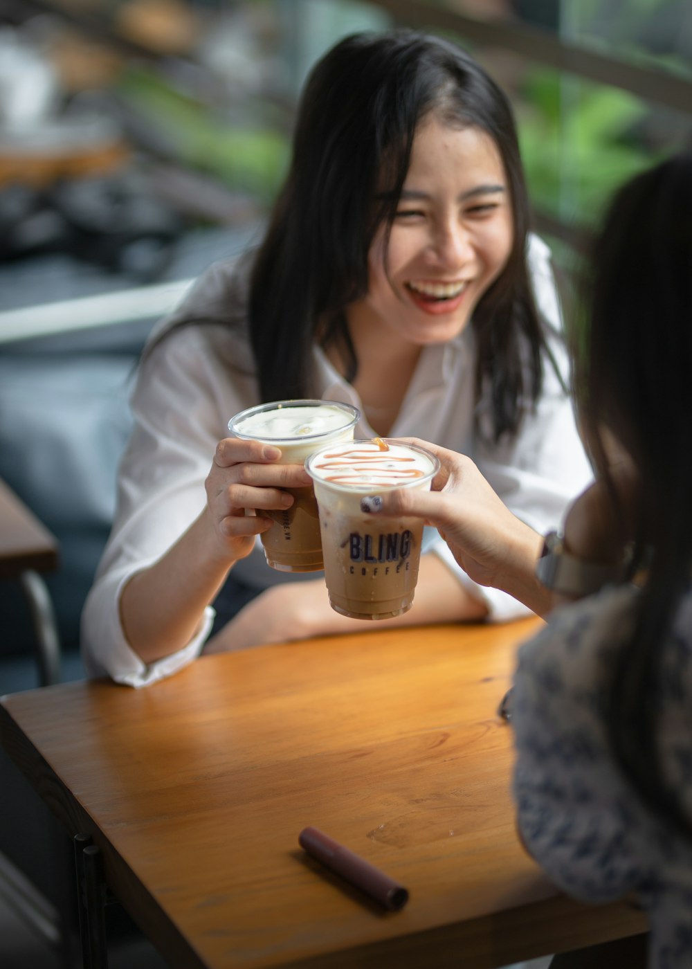 a woman sitting at a table with a cup of coffee