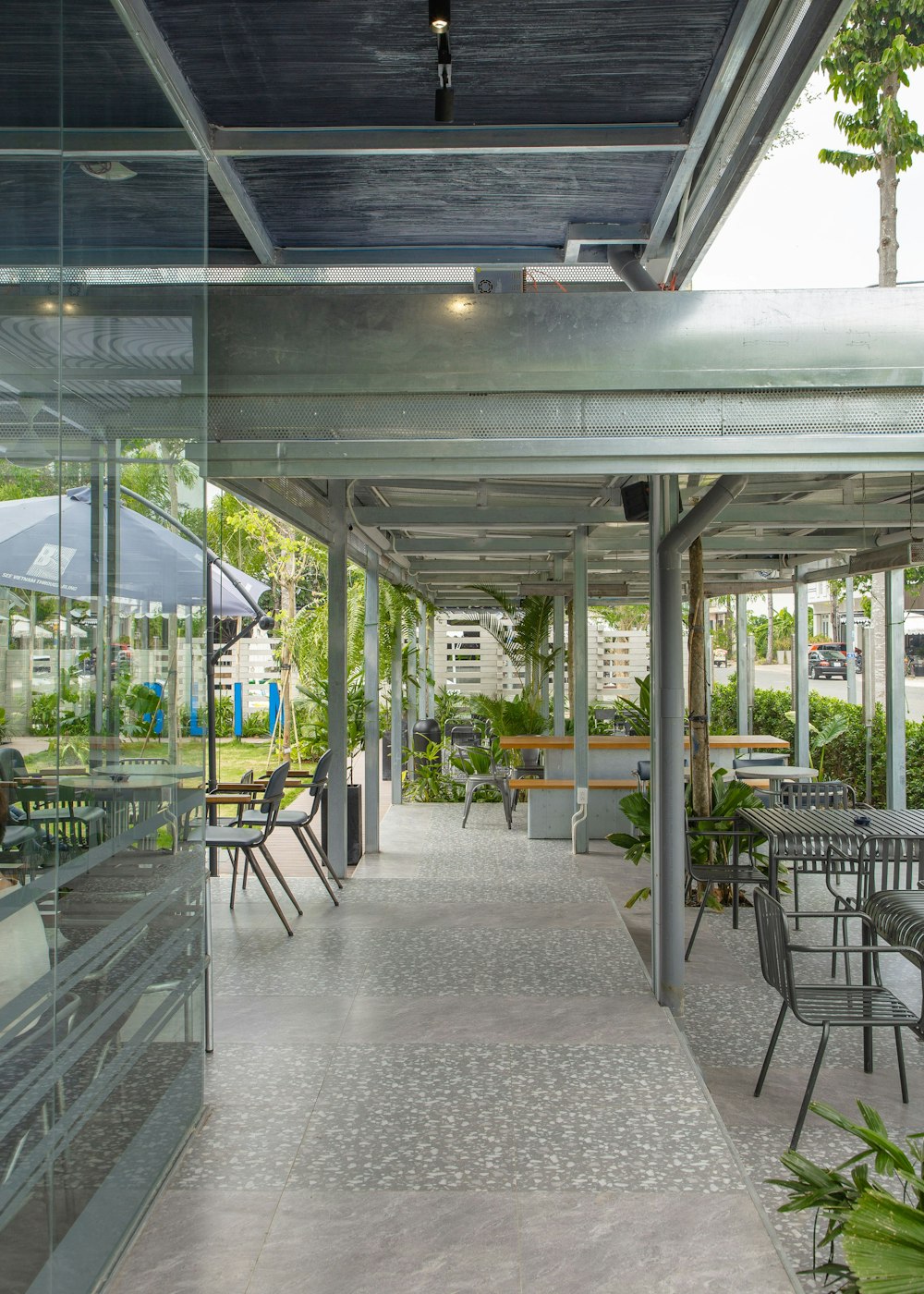 a long covered patio with tables and chairs