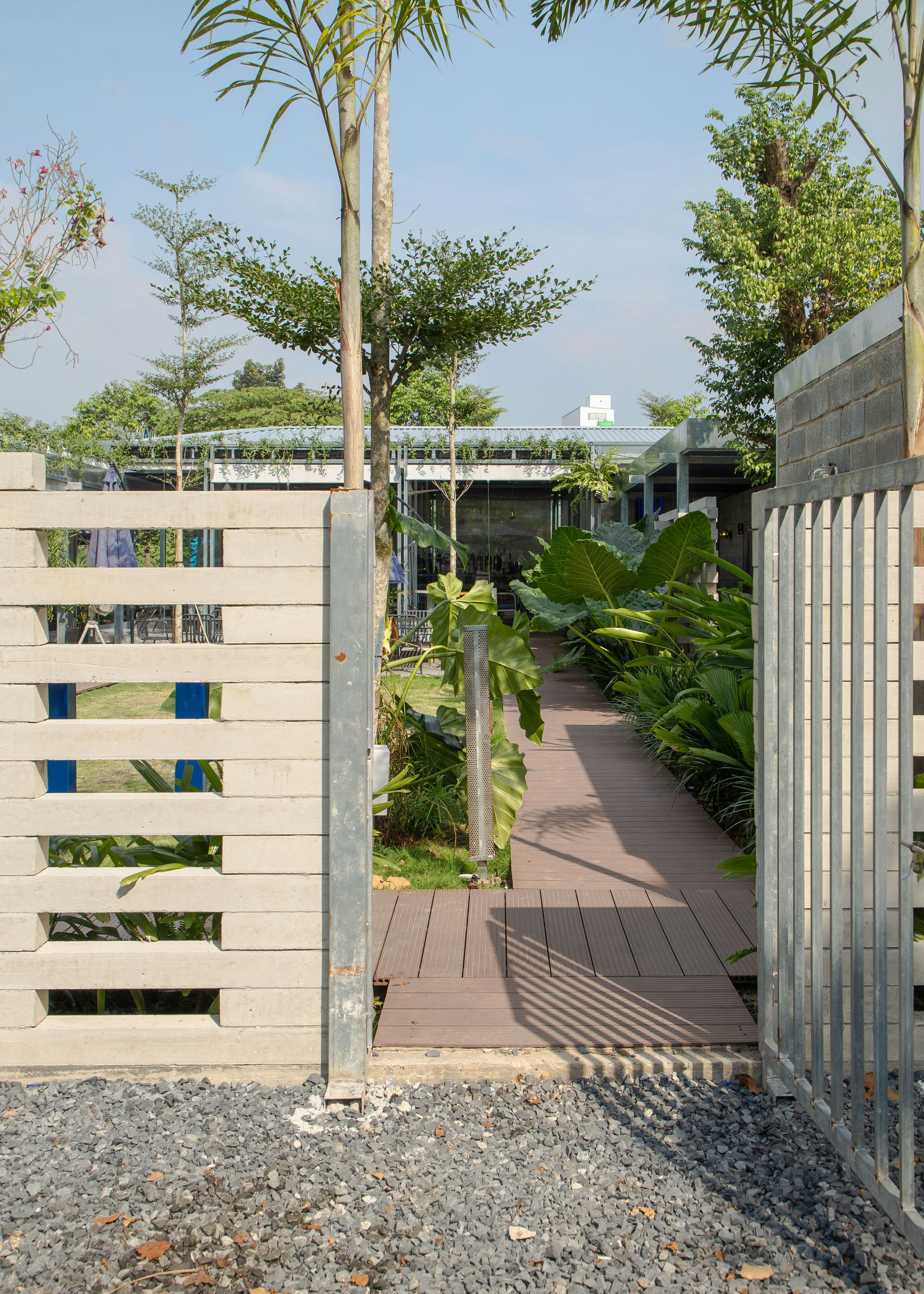 a wooden walkway leading to a building with palm trees