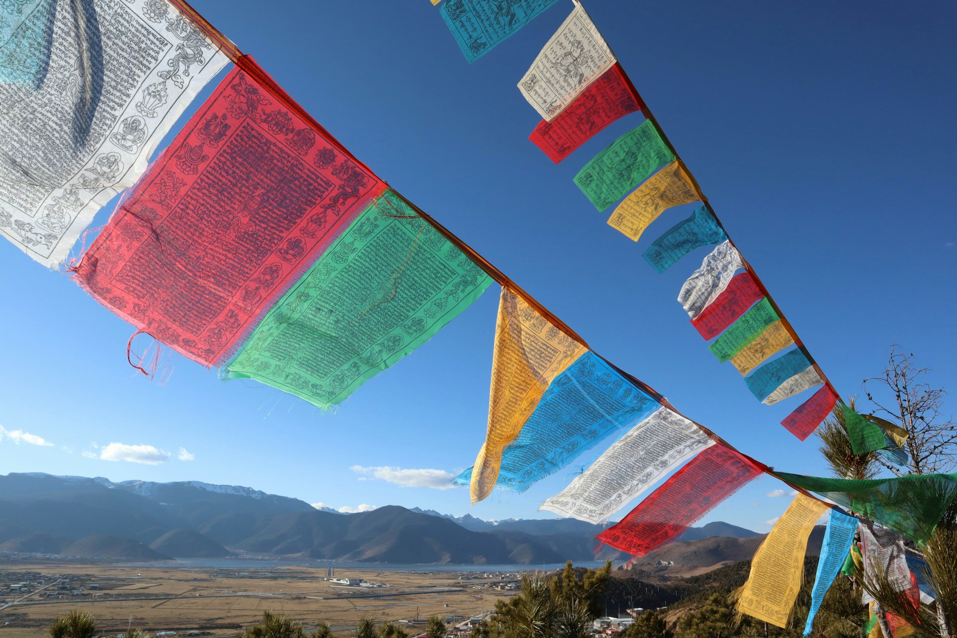 there are many colorful flags hanging in the air