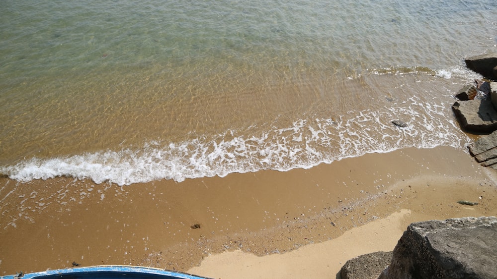 a boat sitting on top of a beach next to the ocean