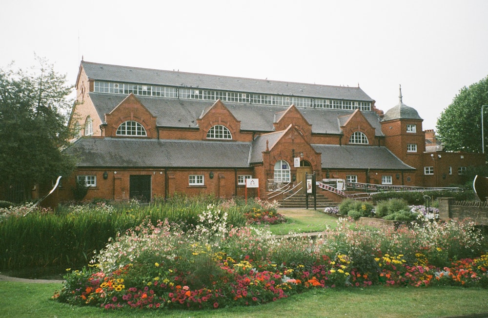 a large brick building with a garden in front of it