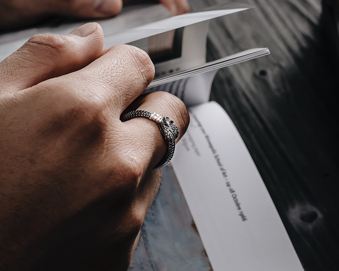 a person holding a knife with a ring on it, Ouroboros Ring