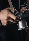 Close-up of Joe Malkovich's hands holding a vintage camera, symbolizing his artistic side.