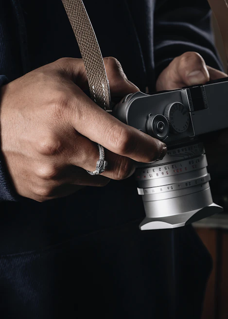 A close-up of a weathered hand holding a vintage camera, capturing moments