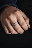 A close-up of a sleek smart ring on a hand.