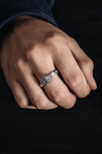 Close-up of a man’s hand wearing a bold gold ring with intricate Incan-inspired designs.