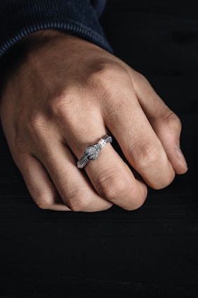 Close-up of a sleek smart ring on a finger with a blurred natural background