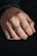 Close-up of a hand wearing a delicate silver ring with soft natural lighting.