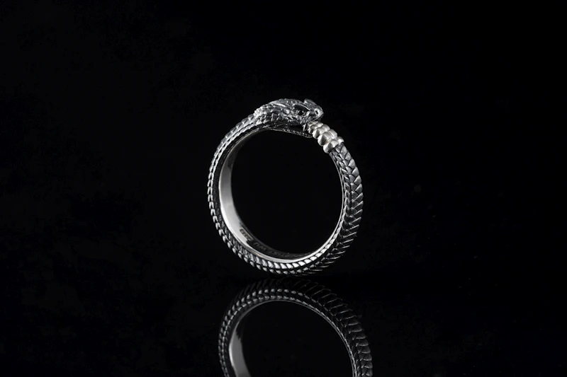 Sculptural gold ring on a dark background