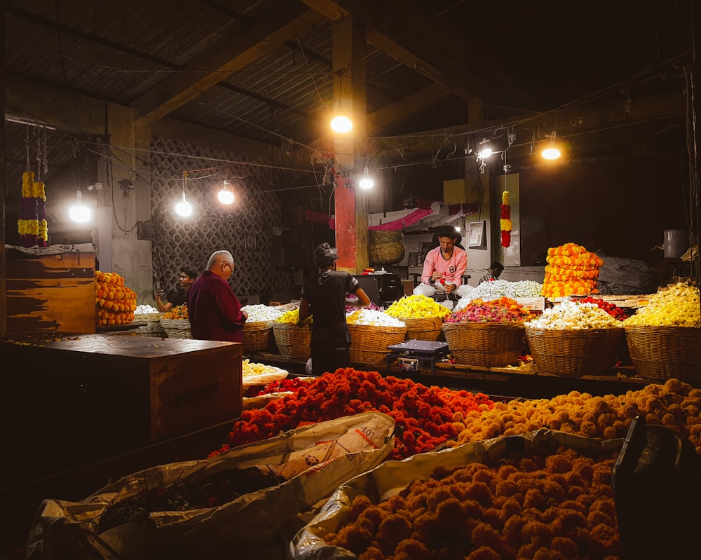 a woman standing in front of a market filled with fruits and vegetables