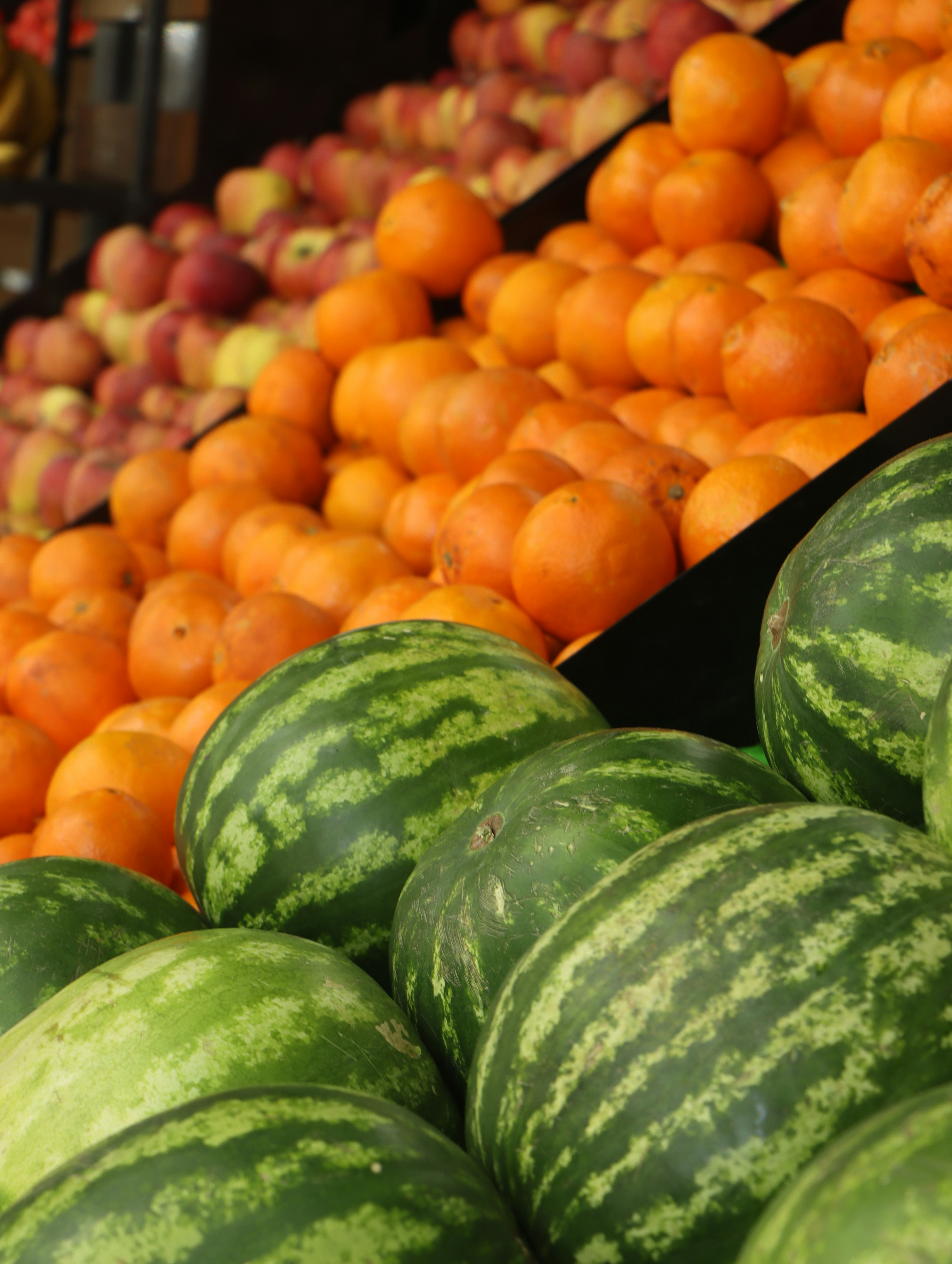 A display of watermelons and oranges in a grocery store photo Free Fruit Image on Unsplash