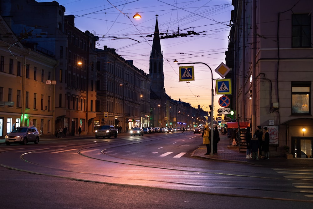 a city street at night with cars driving down it