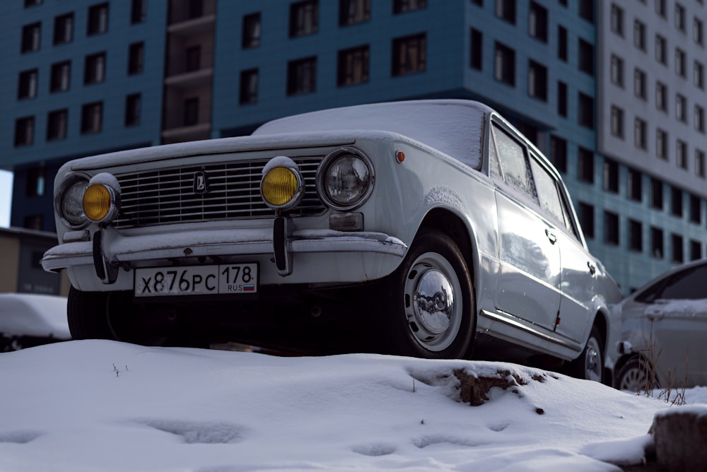 a white car parked on top of snow covered ground