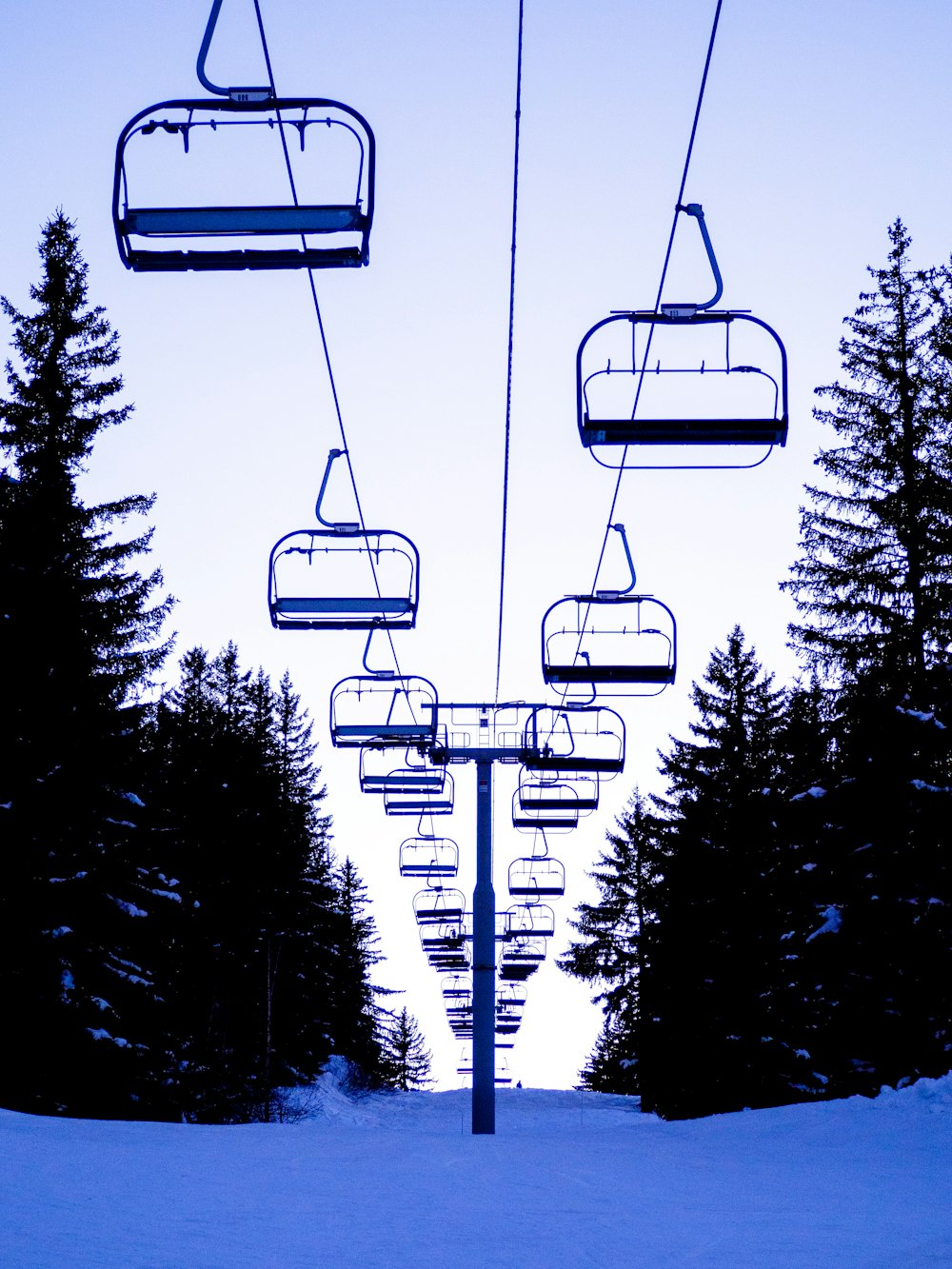 a ski lift going up a snowy hill