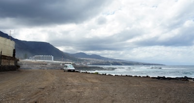 A comfortable rental car parked beside a picturesque coastal road.