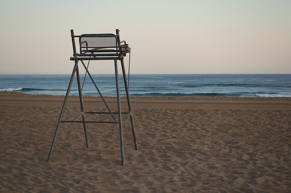 a lifeguard stand on a beach with the ocean in the background