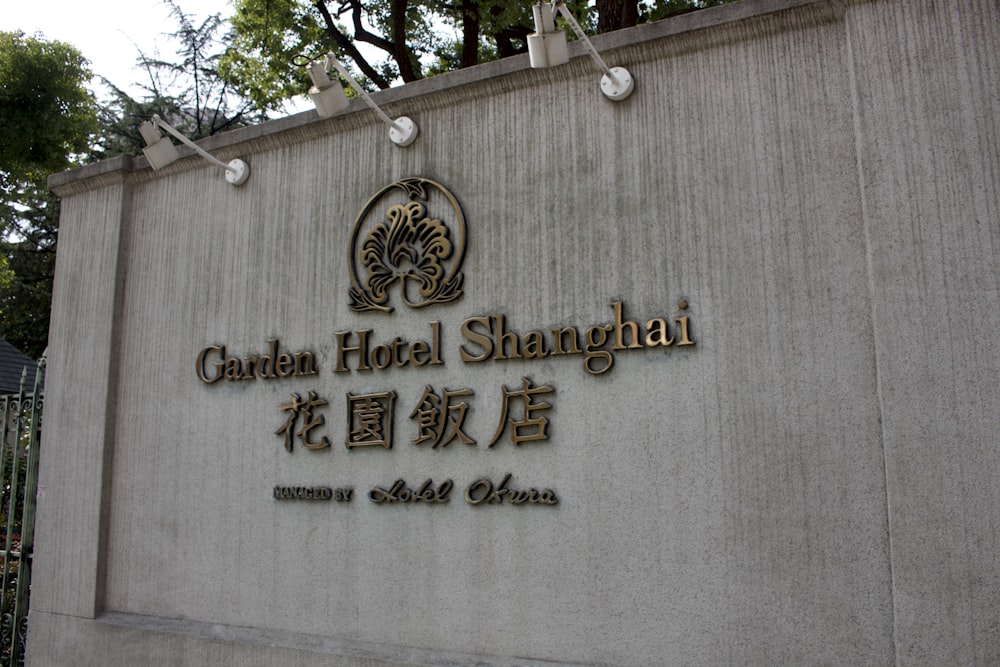 a sign on the side of a building that says garden hotel shanghai