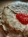 A stack of thin, golden-brown crepes with a dollop of vibrant orange-red caviar on top, creating a contrast in texture and color.