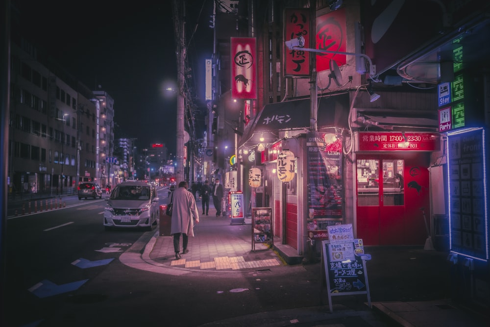 a person walking down a street at night