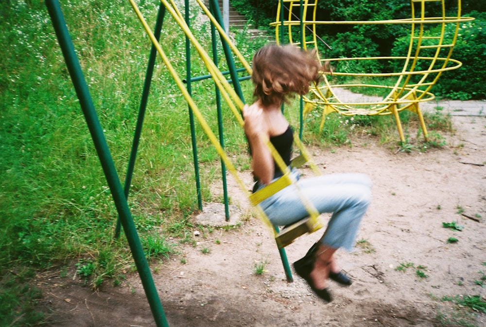 a woman is climbing on a swing set