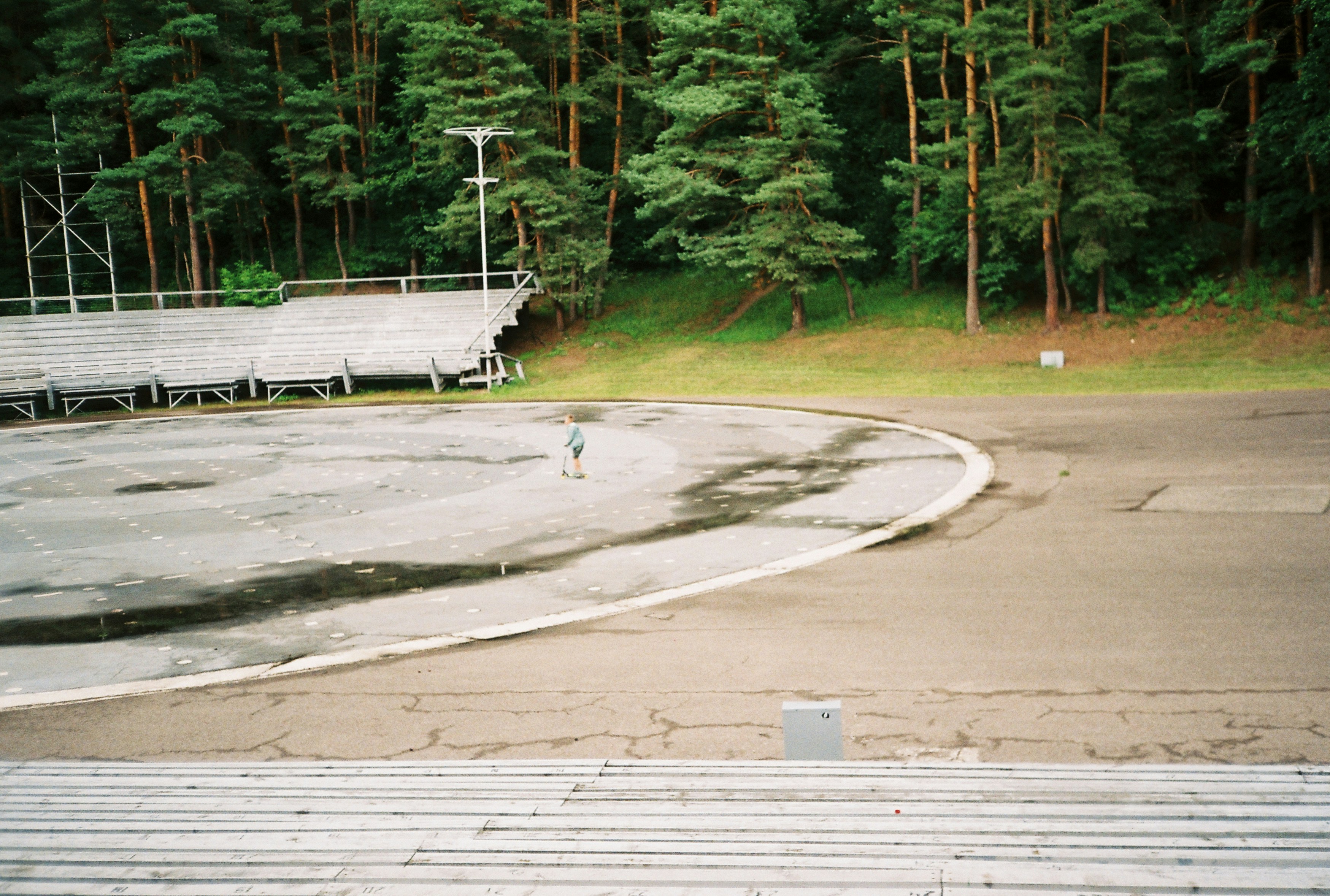 Eine Person, die vor einer Bühne mitten im Wald steht