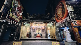 A serene temple entrance adorned with flowers and lamps at dusk.