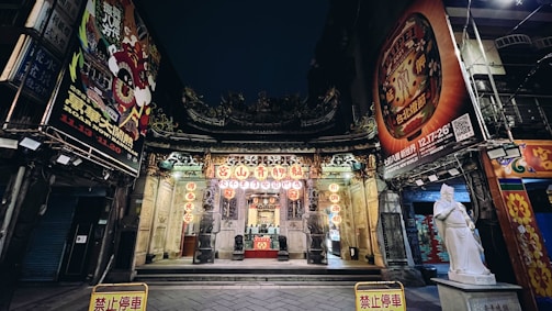 A serene temple entrance adorned with flowers and lamps at dusk.