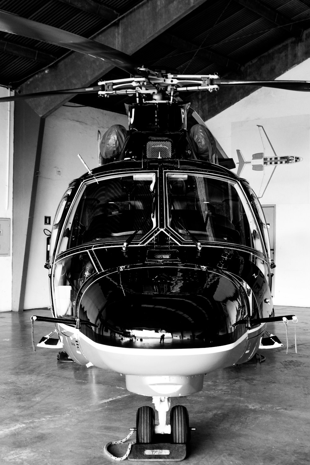 a black and white photo of a helicopter in a hangar