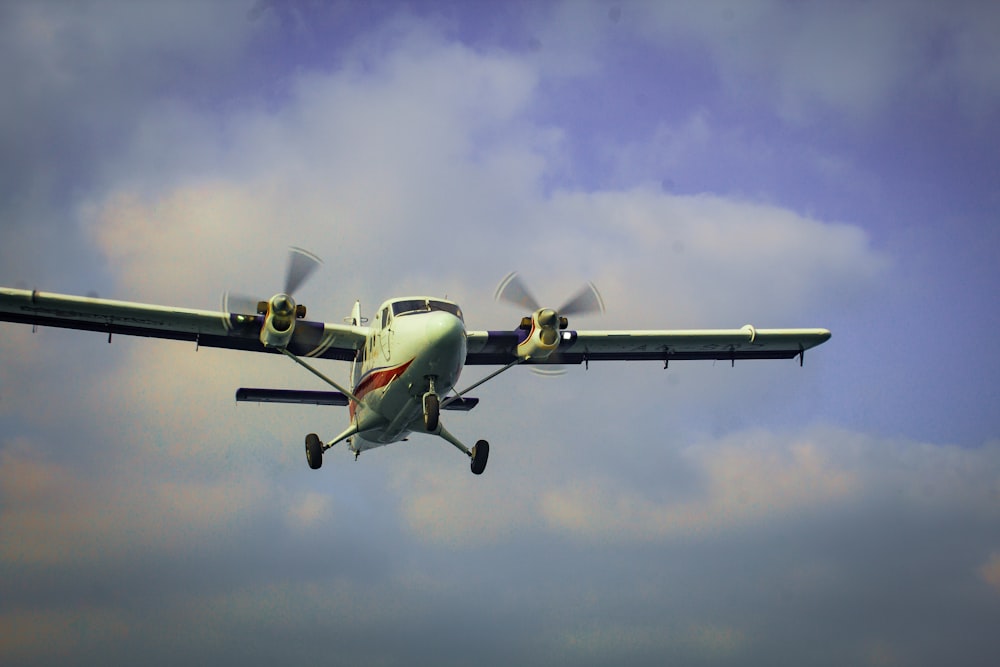 a small propeller plane flying through a cloudy sky