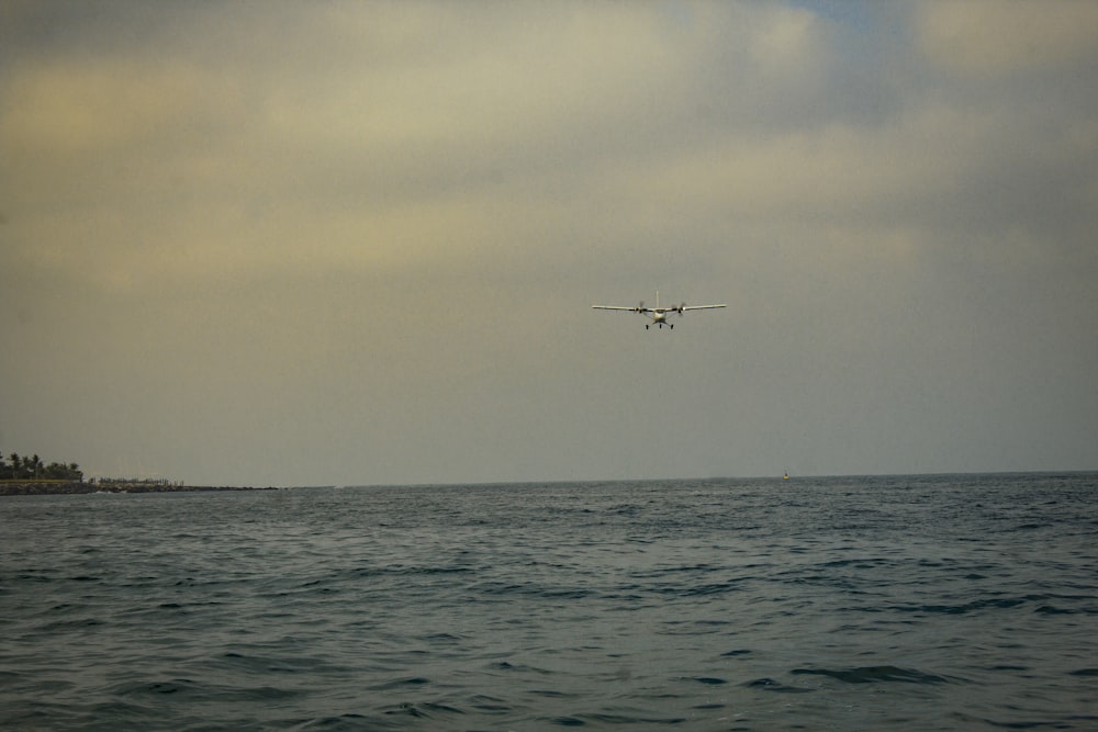 a plane flying over the ocean on a cloudy day