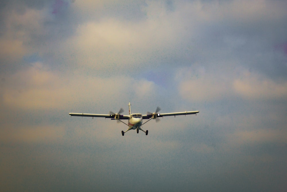 a small airplane flying through a cloudy sky