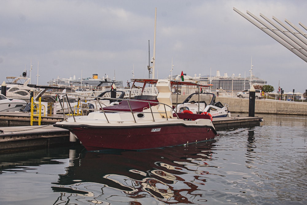 a red and white boat docked at a marina