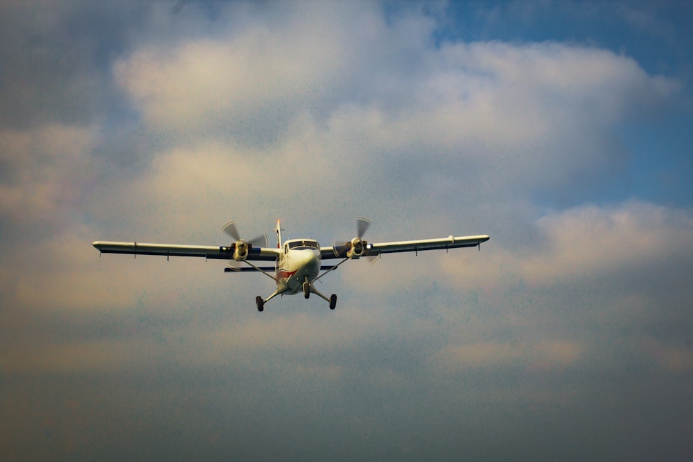 a small airplane flying through a cloudy sky